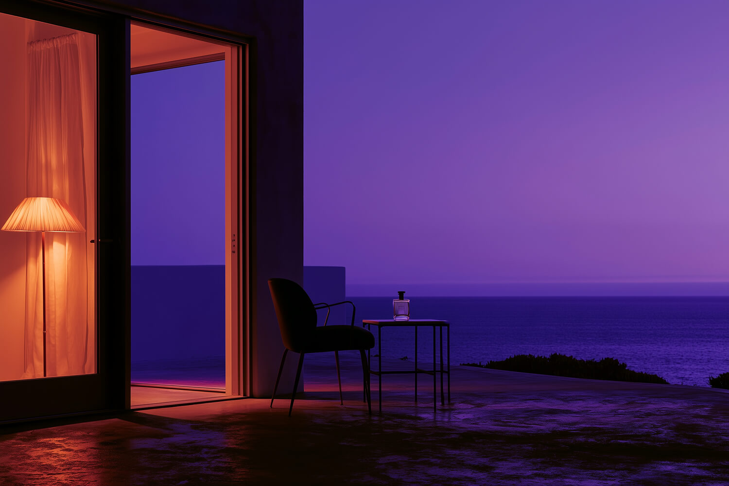 Open doorway from a lamplit room onto a terrace above the sea at dusk